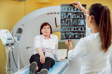 Radiologist with an elderly female patient looking at x-ray.