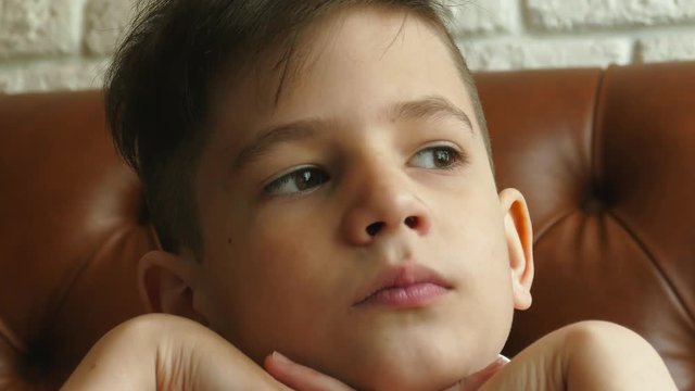 Young kid close up portrait in cafe on sofa