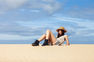 Beautiful hippie woman relaxing on sand. Fashion portrait