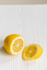 Single sliced lemon on white wooden surface close