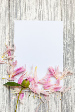 Mockup with postcard and flowers on wooden background