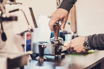 Barista preparing coffee in a cafe. Professional coffee making, service and catering concept