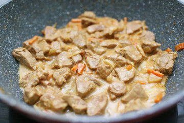 Meat in cream sauce on a pan