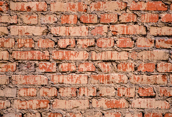 Texture of a brick wall of an old house on a sunny day. Background of brickwork close-up. Architectural vintage masonry. Building grunge of concrete and brick.