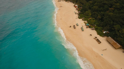 Aerial view of beautiful tropical island with white sand beach, hotels and tourists, Boracay, Puka shell beach. Tropical lagoon with turquoise water and white sand. Beautiful sea, beach, resort