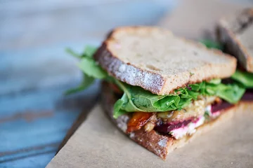 Foto op Plexiglas Snackbar Heerlijk ambachtelijk broodje van gemengde groenten op een houten tafel