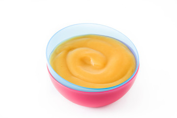 Baby food: colorful bowl of fruit puree isolated on white background