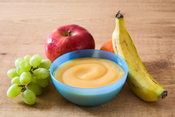 Baby food: colorful bowl of fruit puree on wooden table