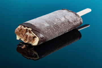 chocolate outer popsicle with beans inside on a blue background close up