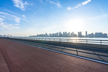 Obraz na płótnie Canvas empty road with panoramic city skyline