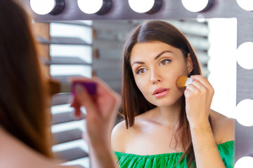 Brunette woman applying make up for a evening date