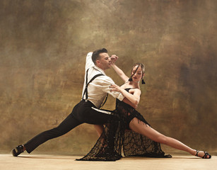 Flexible young modern dance couple posing in studio.