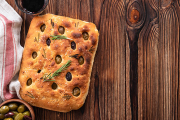 Traditional Italian Focaccia with olives, rosemary - homemade flat bread focaccia. Rustic style. Top view.