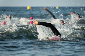 Group people in wetsuit swimming at triathlon