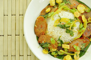spicy stir fried Chinese pork sausage with basil leaf and rice on plate