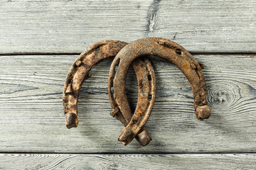 old rusty horseshoes on wooden board
