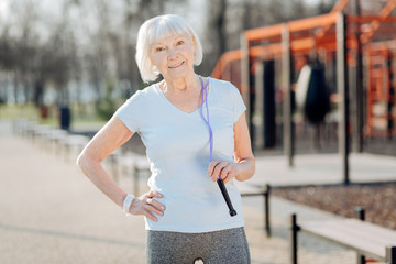 Good shape. Inspired thin woman relaxing while exercising in the open air