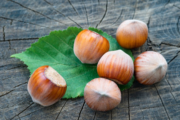 Close-up nut hazelnuts with leaf on old wooden background.