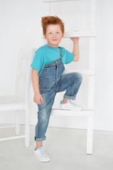 Portrait of red-haired naughty boy looking at the camera. Cute and beatiful children.
