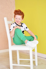 Portrait of red-haired naughty boy looking at the camera. Cute and beatiful children.