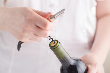 Female opening a bottle of wine