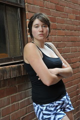 Female beauty expressions against a wall outside.