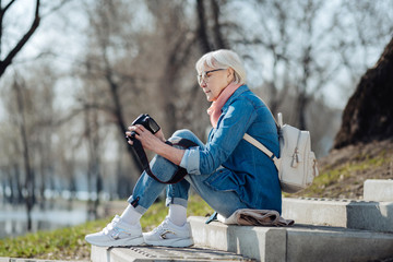 Nice photos. Alert mature woman sitting on the steps and looking through photos