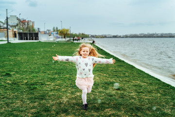 Naklejka premium Little happy pretty girl have fun in the park