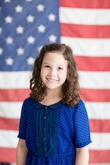 Little girl smiling with American flag background