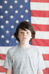 Teenage boy standing with American flag background