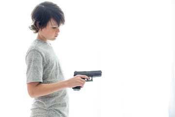 Young teenager holding gun on white background