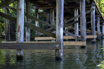 Fototapeta na wymiar Wooden construction under bridge. Vintage bridge bottom view.