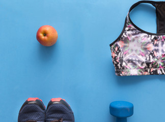 color sports top, blue sports shoes on blue background, dumbbell, Apple, flat lay, color sportswear