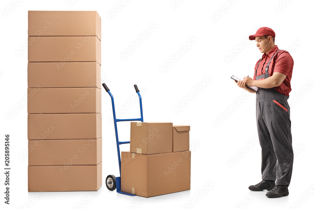 Poster Mover standing next to a hand truck and a stack of boxes writing in clipboard