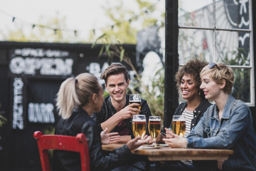 Friends drinking in an outdoor bar in summer