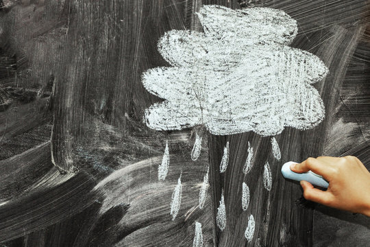 A cloud and a rain drawn with chalk on a blackboard.