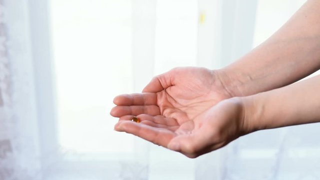 In the hands of a woman falling pills. White background.