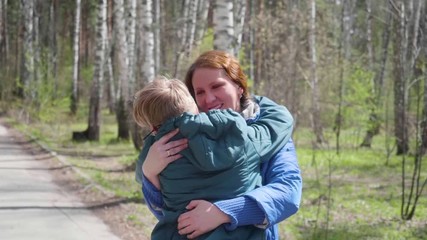 The child runs to his mother, gently hugs her. Happy family, loving parents.