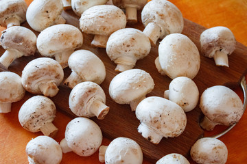 Champignon mushrooms, sacking mat and spices on wooden background