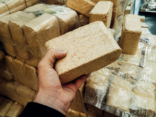 Alternative fuel, eco fuel, bio fuel. Wood sawdust briquettes for stoves. Lean-burn with good heat output. Briquettes from sawdust on a green background.