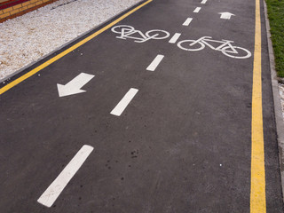 White bicycle sign with arrow on the asphalt, bike road sign on the street, bicycle lane sign on street, gray background