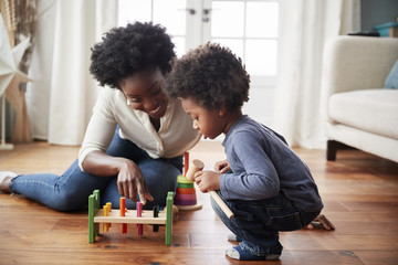 Mother And Young Son Playing With Wooden Toy At Home - Powered by Adobe