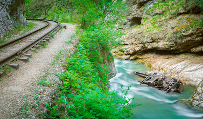 the old locomotive lies on the bottom of a mountain river next to an old narrow-gauge railway under a rock, the Guam gorge of Adygea, the Caucasus