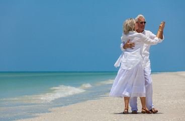 Happy Senior Couple Dancing Holding Hands on A Tropical Beach