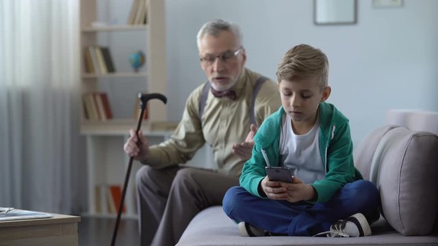 Upset grandfather scolding grandson for using cell phone, internet addiction