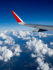 Fototapeta na wymiar View from airplane windows from passenger, beautiful cloud group and blue sky. Wing aircraft in altitude during flight.Concept of travel and business trip. Traveling concept.