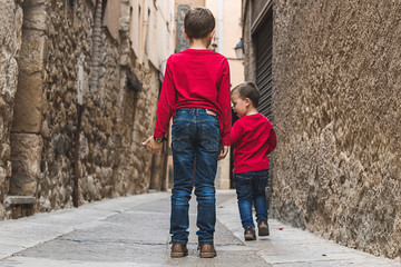 Obraz na płótnie Canvas Children walking on their backs on the street