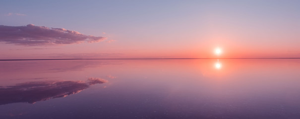 Landscape beautiful golden sunset red sky solt lake saline Elton Baskunchak. The sun sets behind...