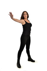 Obraz premium full length portrait of brunette girl wearing black singlet, jeans jeans and boots. standing pose, isolated on white studio background.