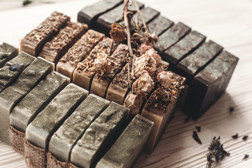 natural soap. handmade herbal soap with wildflowers, healing flowers, mint, dried lavender, top view. eco natural product for skin care. soap on white rustic background with dried herbs